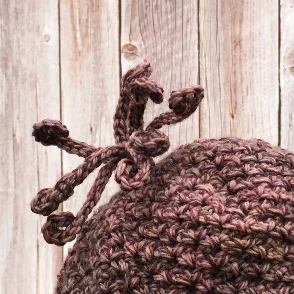 Hand crocheted hat in a dusty plum tweed.
