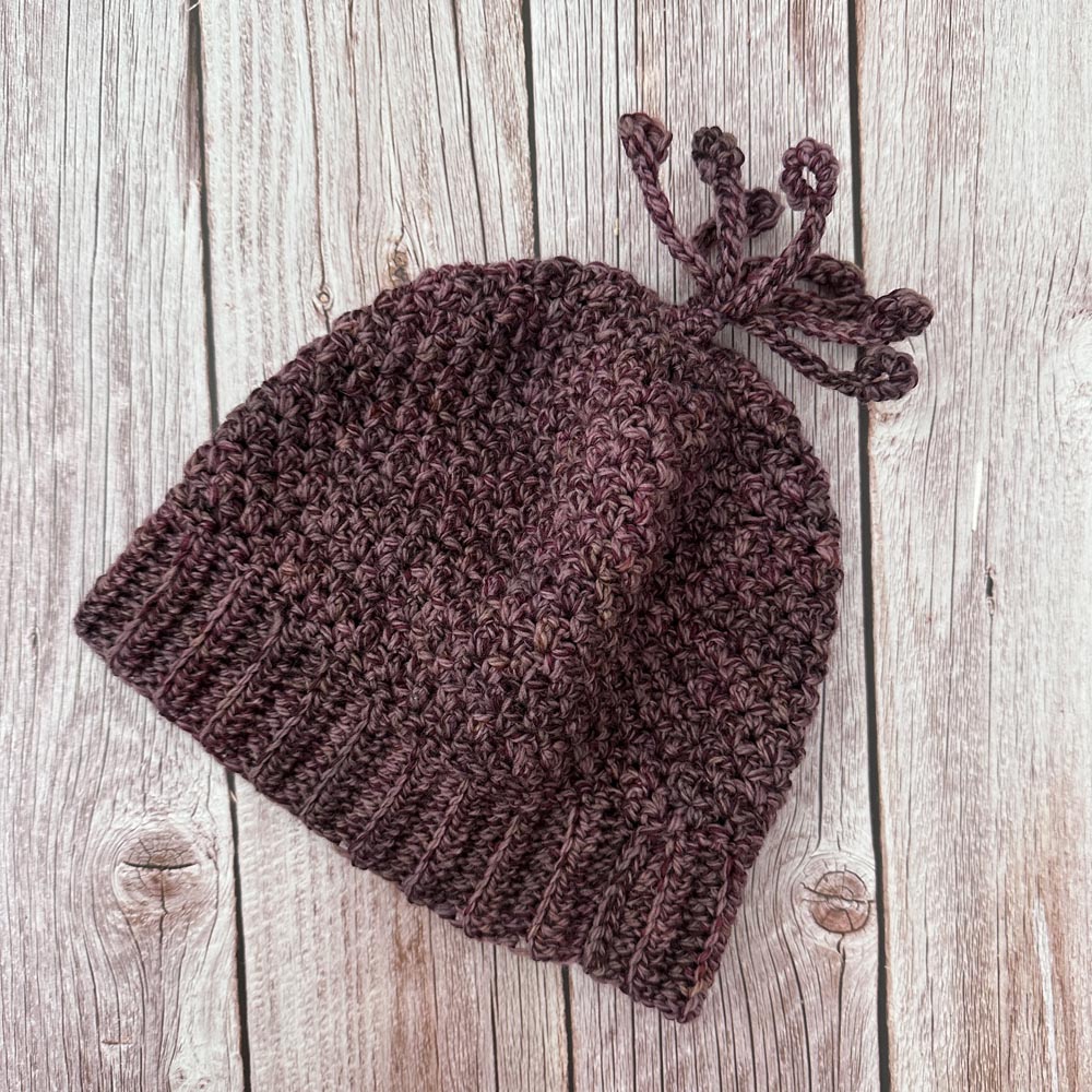 Hand crocheted hat in a dusty plum tweed.